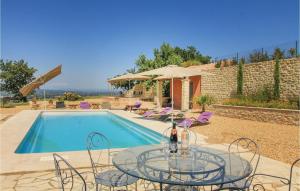 een glazen tafel en stoelen naast een zwembad bij Gorgeous Home In Cairanne With Wifi in Cairanne