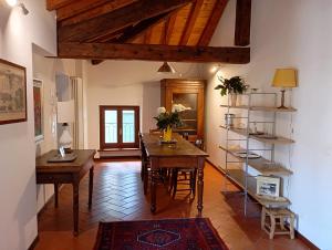 ein Wohnzimmer mit einem Tisch und Stühlen sowie ein Zimmer mit Holzdecken in der Unterkunft La Finestra Sul Civico Cinque in Verona