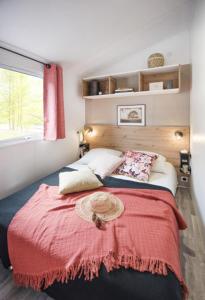 - une chambre avec un grand lit et une couverture rouge dans l'établissement CAMPING PLEIN SOLEIL, à Lourdes