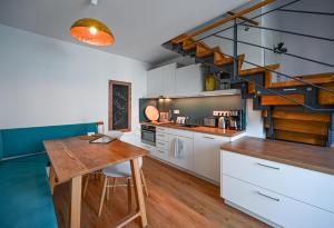 a kitchen with a wooden table and a spiral staircase at EntdeckerFERIEN am Bodensee in Friedrichshafen