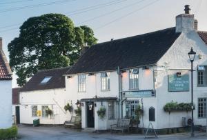 a white building with a sign in front of it at Luxury Farm Cottage with Hot Tub in Northallerton