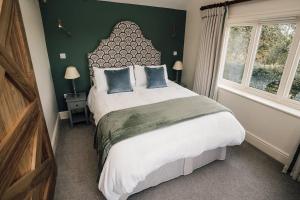 Un dormitorio con una cama grande y una pared verde en Luxury Farm Cottage with Hot Tub, en Northallerton