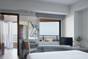 um quarto com uma cama e uma secretária com uma televisão em Lato Boutique Hotel em Heraclião