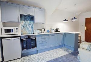 a kitchen with blue cabinets and white appliances at Allerdale in Torquay