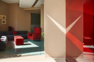 sala de estar con sofá y sillas rojas en Lato Boutique Hotel, en Heraclión