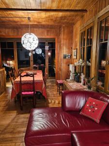 sala de estar con mesa y sofá de cuero en Magnifique Chalet Valérie 5 chambres à coucher & vue unique, en Gryon