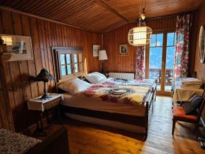 グリヨンにあるMagnifique Chalet Valérie 5 chambres à coucher & vue uniqueの木製の壁のベッドルーム1室(大型ベッド1台付)