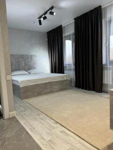塔拉茲的住宿－Al-Karakhan，一间卧室配有一张大床和黑色窗帘