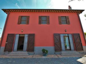 Casa roja con puertas y ventanas marrones en Chic Farmhouse in Montalto di Castro with Terrace, en Montalto di Castro