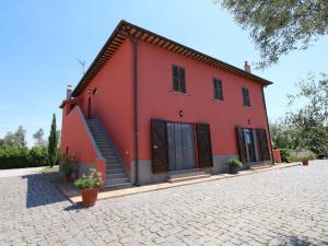 una casa roja con una entrada de ladrillo delante de ella en Chic Farmhouse in Montalto di Castro with Terrace, en Montalto di Castro