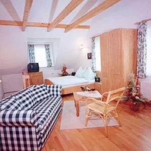 - un salon avec un canapé et un lit dans l'établissement Ferienhof Uhudler-Arkaden, à Stegersbach