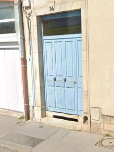 a blue door on the side of a building at Charmant appartement avec jardin in Nancy