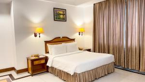 Hotel Sor في بنوم بنه: غرفه فندقيه بسرير ونافذه