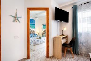 コラレホにあるCasa Vista Isla de Lobosの鏡、ベッド、デスクが備わるベッドルーム1室が備わります。