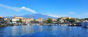 un port avec une ville et une montagne en arrière-plan dans l'établissement Casa Angelina a due passi dal mare, à Acireale