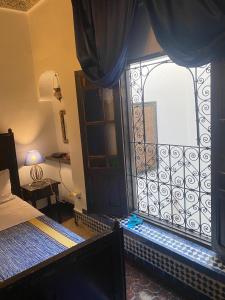 a bedroom with a window with a bed and a bed sqor at Charmant Ryad à 1mn de BAB BOUJLOUD DAR SERRAJ in Fez