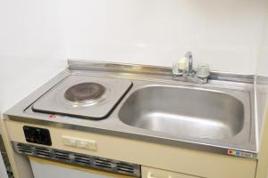 a kitchen with a sink and a stove at メゾンファミール成瀬 in Machida