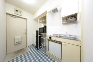 a small kitchen with a sink and a refrigerator at メゾンファミール成瀬 in Machida