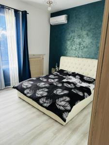 Schlafzimmer mit einem Bett mit einer schwarzen und weißen Bettdecke in der Unterkunft Nido di tranquillità in San Mauro Pascoli