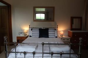 a bedroom with a bed with two lamps and a mirror at Cosy 2-bedroom cottage in the Lake District in Bowness-on-Windermere