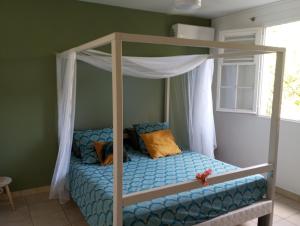a bedroom with a bunk bed with a canopy at Les poinsettias in Les Trois-Îlets
