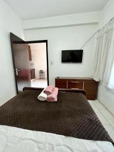 um quarto com uma cama com duas toalhas cor-de-rosa em Selva Guazú Apart em Puerto Iguazú