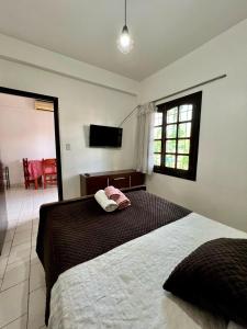 um quarto com uma cama e uma televisão de ecrã plano em Selva Guazú Apart em Puerto Iguazú
