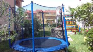 a blue trampoline in a yard with a playground at Lopar Apartment 1 in Lopar