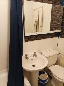 La salle de bains est pourvue d'un lavabo, de toilettes et d'un miroir. dans l'établissement UnknownRooms, à Londres