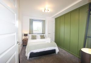a bedroom with a bed and a green wall at City Apartment by the Castle, Free Parking. in Stirling