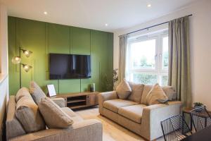 a living room with two couches and a flat screen tv at City Apartment by the Castle, Free Parking. in Stirling