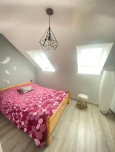 a bedroom with a bed with pink sheets and a window at appartement T3 idéalement situé in Eygliers