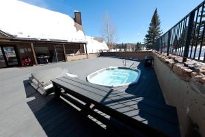 ein Whirlpool auf einer Terrasse neben einer Bank in der Unterkunft Cascade Village 56 in Durango Mountain Resort