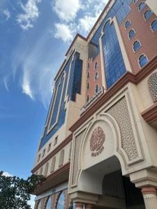 برج الوطن للاجنحه الفندقية في مكة المكرمة: مبنى طويل مع سماء زرقاء في الخلفية