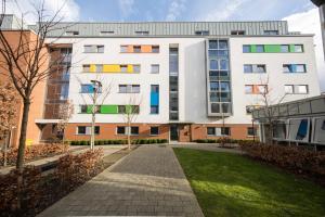 a large white building with colorful windows and a sidewalk at Wenlock Court in Luton