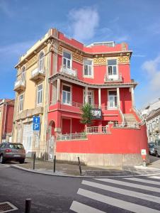 a red building on the corner of a street at OLOPO Hostel in Porto