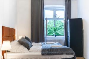 a bedroom with a large bed with a window at Pleasant 2BR Apt- Near Train Station Hetzendorf in Vienna