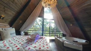 a bedroom with a bed and a tub and a purple butterfly at Chalé Capivari Esmeralda in Campos do Jordão