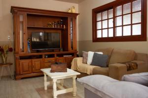 een woonkamer met een bank en een tv bij Casa Baseggio in Canela