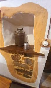 Un vaso che si posa su uno scaffale in un muro di Un Tuffo nel passato "B&B Santu Giuvanni" a Fonni