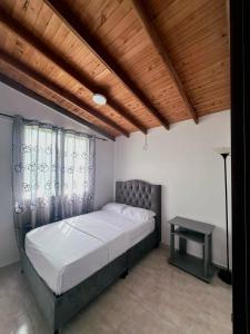 a bedroom with a bed and a table in it at Despertar Cafetero in Dosquebradas