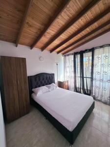 a bedroom with a large bed with a wooden ceiling at Despertar Cafetero in Dosquebradas