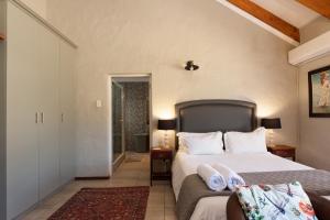 een slaapkamer met een groot bed met witte lakens bij Owls Nest Self Catering in George