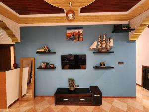 un soggiorno con parete blu, scaffali e tavolo di Winou Surf House ad Aourir