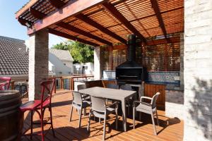 a patio with a table and chairs and a stove at Owls Nest Self Catering in George