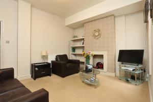 a living room with a couch and a tv at Apartment in the heart of Cheltenham/ Parking in Cheltenham