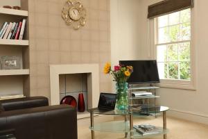 una sala de estar con una mesa de cristal con flores. en Apartment in the heart of Cheltenham/ Parking, en Cheltenham