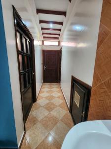 un corridoio vuoto con una porta e un pavimento piastrellato di Winou Surf House ad Aourir