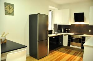リスボンにあるMarques Classy Apartment by be@homeのキッチン(ステンレス製の冷蔵庫、壁掛け時計付)