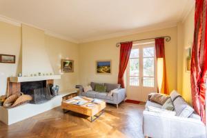 a living room with two couches and a fireplace at Domaine des sources - Welkeys in Orange